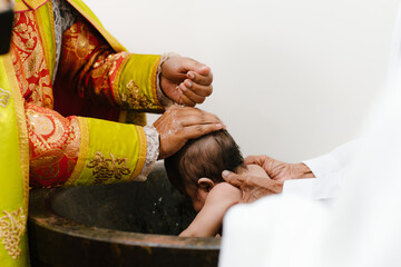priest blessing baby during baptism