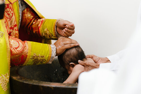 priest blessing baby during baptism