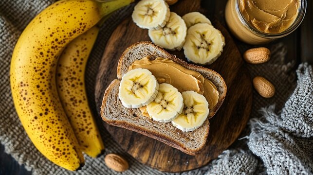 A delicious breakfast featuring whole grain toast topped with peanut butter and banana slices, accompanied by fresh bananas and almonds.
