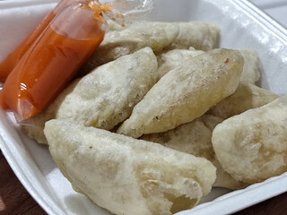 Cireng is an Indonesian street food, white semi-circular shaped made from starch flour and filled with seasoned shredded chicken.