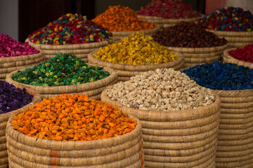 Traditional spices market. Pots and wooden tubs stand in row with colorful tea, spices, fruits, roots, flowers. Street bazaar. Dubai, UAE