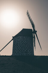 View of the old, typical windmills of Villaverde, Fuerteventura, Canary Islands, with their wooden blades. almost sunset, oblique light, golden hour. Past, vintage feeling.