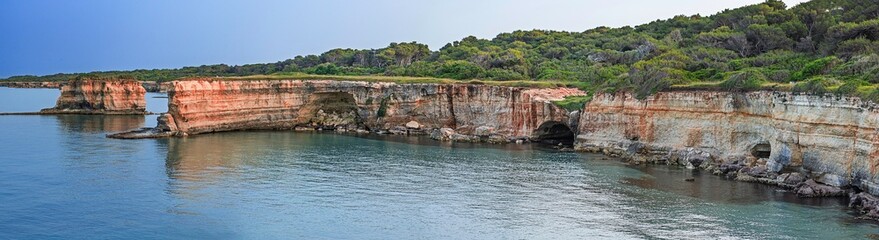 Fototapeta premium Panoramic view of Salento coastline, Puglia, Italy. Rocky cliffs, clear waters, and lush vegetation. Captures the natural beauty of the Adriatic coast...