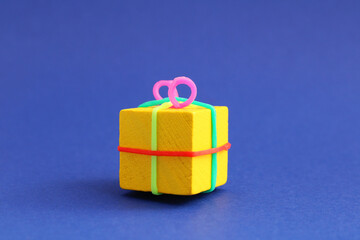 Cube and colorful rubber bands forming a gift box