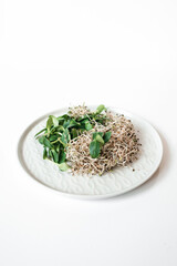 Sunflower and alfalfa sprouts on a plate on a white background. Microgreens, Healthy eating, salad...