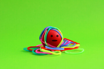 Facial expression on a sphere tied with colorful rubber bands
