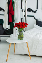 Bouquet of red roses on the white table. Room for newlyweds.