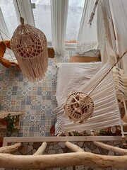 A cozy Boho-style bed with knitted lace lamps, flounce pillows and a white canopy. view from above....