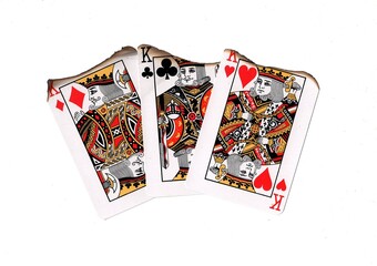 A hand of vintage playing cards showing three partly burnt kings on a white background.