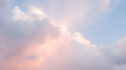 Soft pastel sky with light pink and blue clouds at twilight.