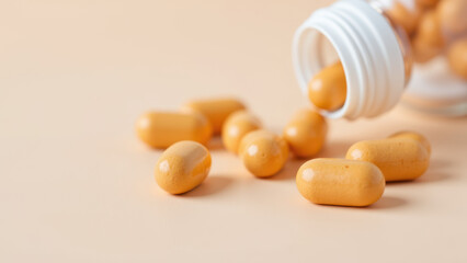 A close-up view of several orange magnesium glycinate capsules scattered on a light surface with one being poured from a clear plastic bottle.