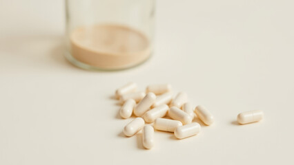 Magnesium Glycinate dietary supplement capsules on a tabletop next to their glass jar.