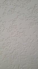 Close view of a textured wall illustrating intricate patterns and design created by plastering techniques in natural light