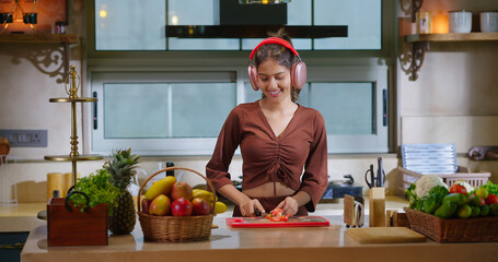 Indian Asian happy young adult gen z woman lady wear headphone online music mp3 enjoy day sing song...