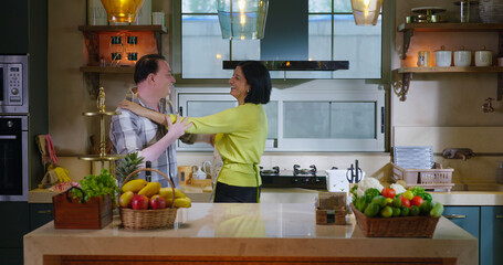 Indian Asian happy gen x lovely couple pair hold hand do casual waltz dance music feel good indoor home wife man women male female lady mom dad love care mood have fun joy enjoy spend day time