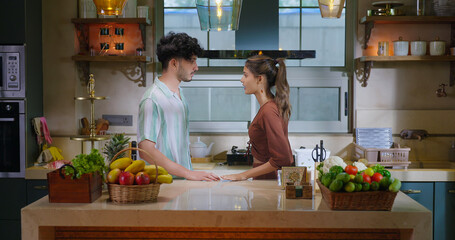 Indian upset tense teen age girl boy male female guy couple standing indoor kitchen talk lies do...