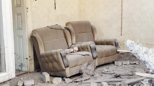 Girl baby doll laying on armchair. Broken concrete in the background. Horror look. Two clips  combined