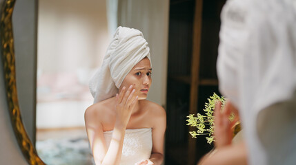 Indian upset young adult gen z woman lady wrapped towel on head and body look mirror feel sad...