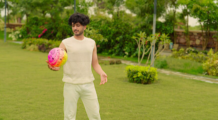 Indian Asian happy alone young adult gen z man cute teen age male boy guy do warm up playing ball in air playful game leisure activity day holiday spend time have fun joy outdoor house park garden