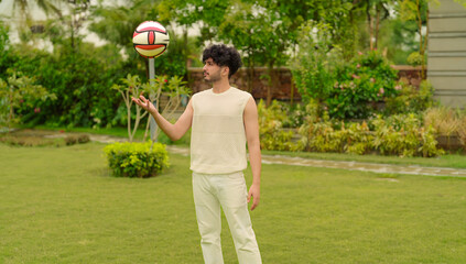 Indian Asian happy alone young adult gen z man cute teen age male boy guy do warm up playing ball in air playful game leisure activity day holiday spend time have fun joy outdoor house park garden