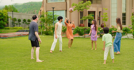 Fototapeta premium Indian happy family young man woman group play ball game throwing in air have fun joy enjoy outdoor park garden Playful cute teen girl son child kid boy with adult mom lady dad spend day time outside 