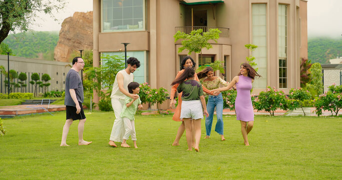 Indian happy family group play game running with cute son kid boy enjoy day outdoor home park Adult mom dad man woman young male female teen girl child have fun joy spend time at outside garden house - Powered by Adobe