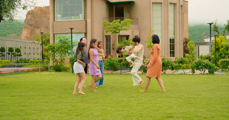 Indian happy family group play game running with cute son kid boy enjoy day outdoor home park Adult mom dad man woman young male female teen girl child have fun joy spend time at outside garden house