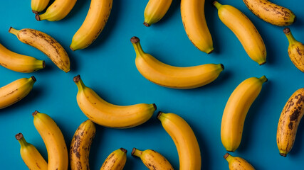 Flat lay banana pattern on blue background, top view.