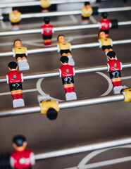 Group of friends playing kicker in a sports bar room, colleagues teammates play table football,...