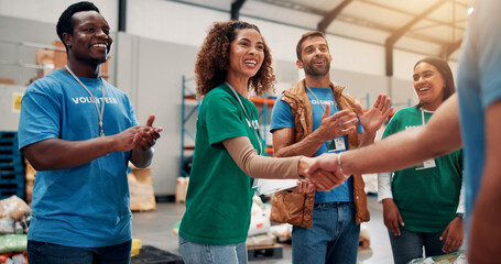 Applause, handshake and support with volunteer team in warehouse together for aid, community or...