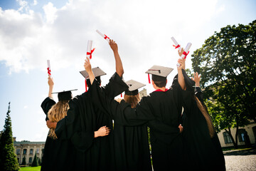 Rear photo of group students groupmates embrace raise diploma mortarboard graduate university...