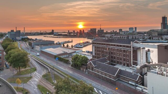 Aerial panoramic view over Maashaven timelapse at sunset with moored inland ships, Katendrecht and Maas River in Rotterdam. Former factory converted into office and event space. Traffic along roads