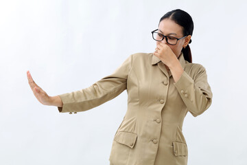 Indonesian civil servant covering her nose and denied something from side. Bad smell concept