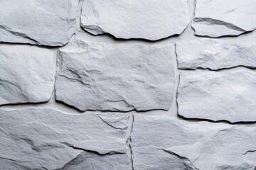 Fototapeta premium A textured wall made of light-colored stones, arranged irregularly, showcasing a natural and rustic appearance.