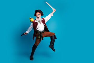 Photo of cheerful man robber pirate hold weapon fight isolated on blue color background