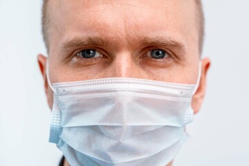 Portrait of a young Caucasian male doctor in a blue uniform on an isolated background. Male...