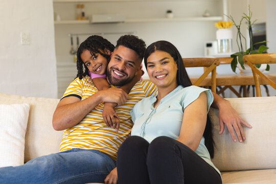 Smiling family relaxing on sofa at home, enjoying quality time together