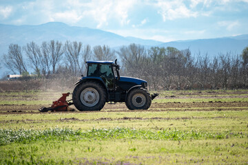 Obraz premium side view of tractor preparing the fields for cultivation