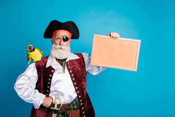 Photo portrait of bearded pirate man hold picture frame wear hallooween costume isolated on blue color background