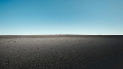Obraz premium Barren Horizon: An expansive and desolate landscape of a barren ground, stretching endlessly beneath a vast, clear blue sky, evoking a sense of solitude and the raw power of nature.