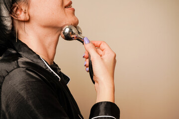 The soft lighting emphasizes her natural beauty. A woman enjoys a relaxing facial massage with a...