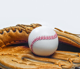 Vintage baseball glove and ball with red stitching on white surface