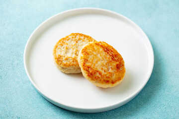 Chicken patties, cutlets on a white plate. Blue background. Close up.