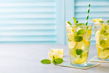 Lemonade, lemon ice tea, mint cocktail in glass. Blue background. Copy space. Close up. © annapustynnikova