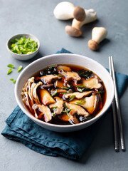 Miso soup with mushrooms. Traditional Japanese food. Grey background. Close up.