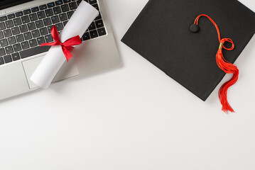 Image showcasing a graduation cap and rolled diploma resting on a laptop keyboard