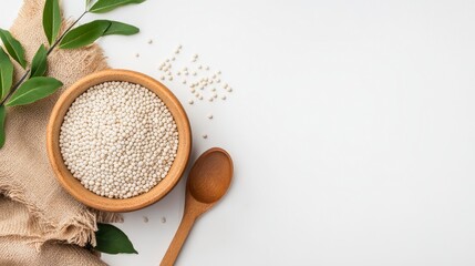 Quinoa and Wellness: A high-angle, studio shot showcases a wooden bowl brimming with quinoa, alongside a wooden spoon and leafy branch, signifying healthy eating and dietary fiber.
