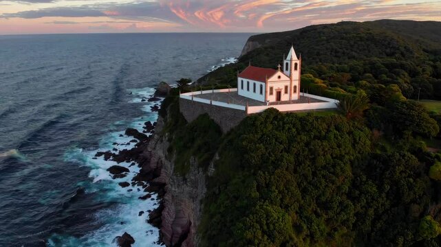 Church perched on a cliff overlooking the ocean at sunset in a scenic coastal location