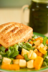 Close-up of a sandwich with fruit salad and greens