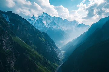 Fototapeta premium Stunning panoramic view of a deep mountain valley framed by jagged snow-capped peaks and misty light rays. A dreamlike alpine scene perfect for travel, nature, fantasy, or cinematic landscapes.